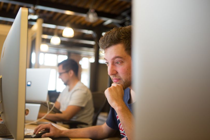 Two employees working on computers at the Decide office