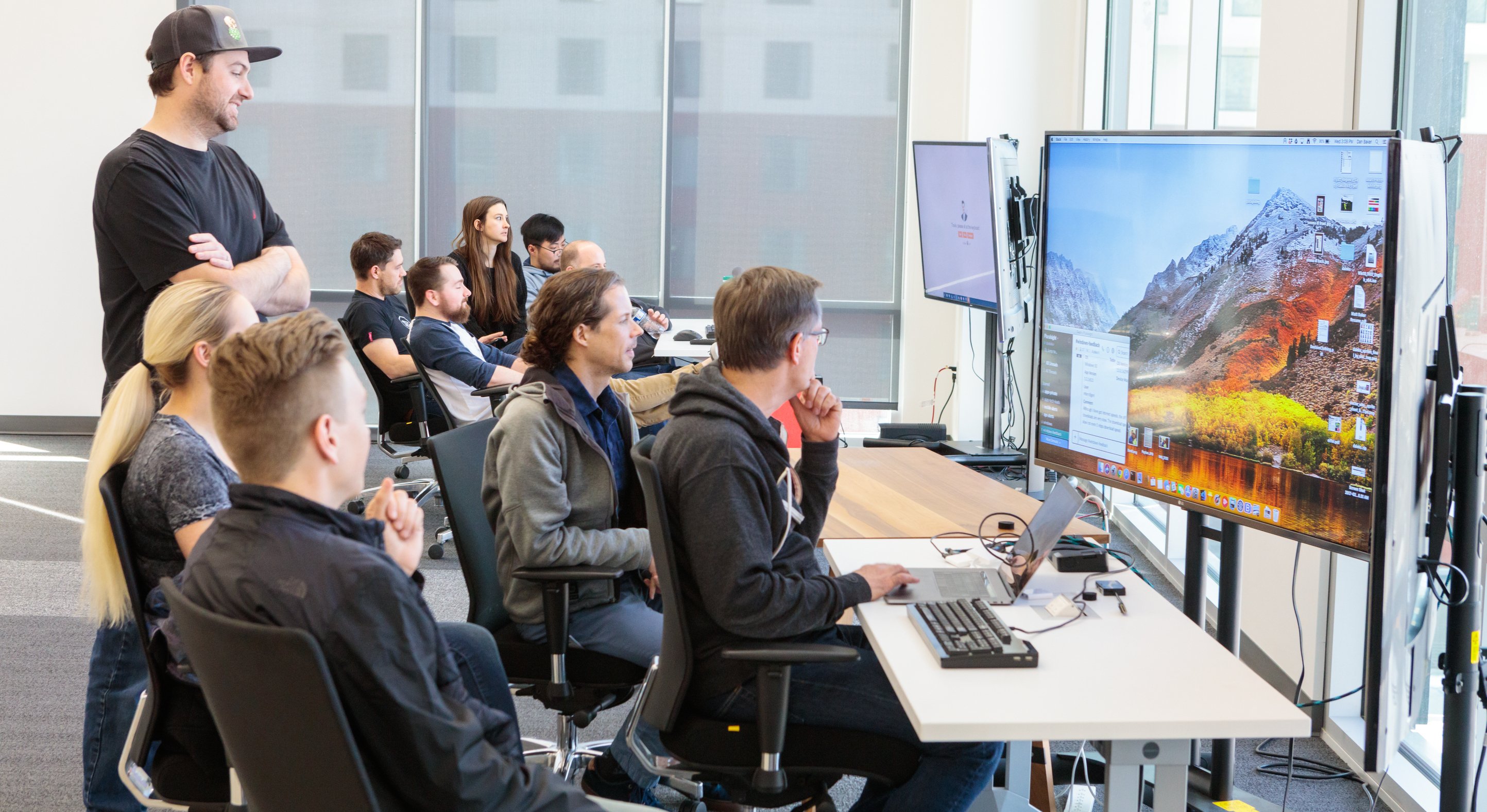 Pluralsight team members gather around a computer.