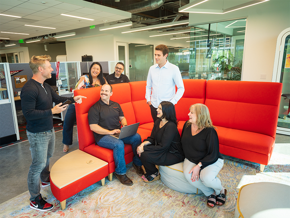 Candid picture of Restaurant365 team members gathered in a common area, talking and laughing.