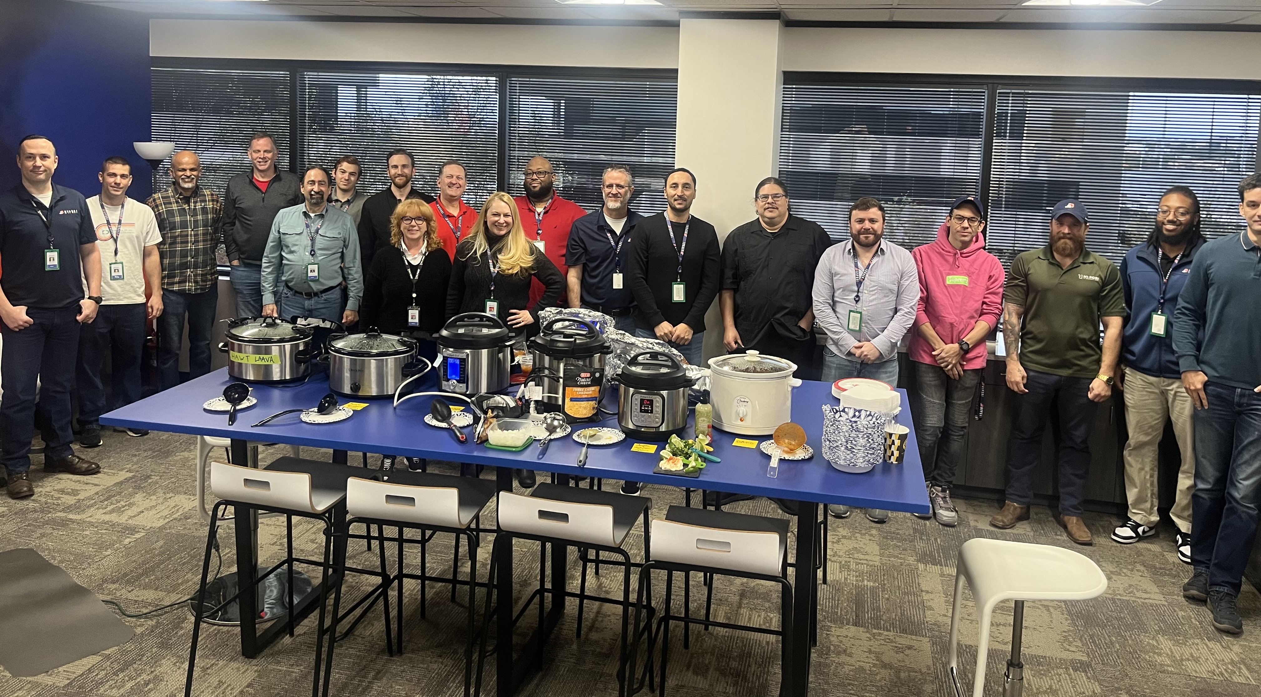 Hypori team members post for picture with crockpots on table at chili cookoff