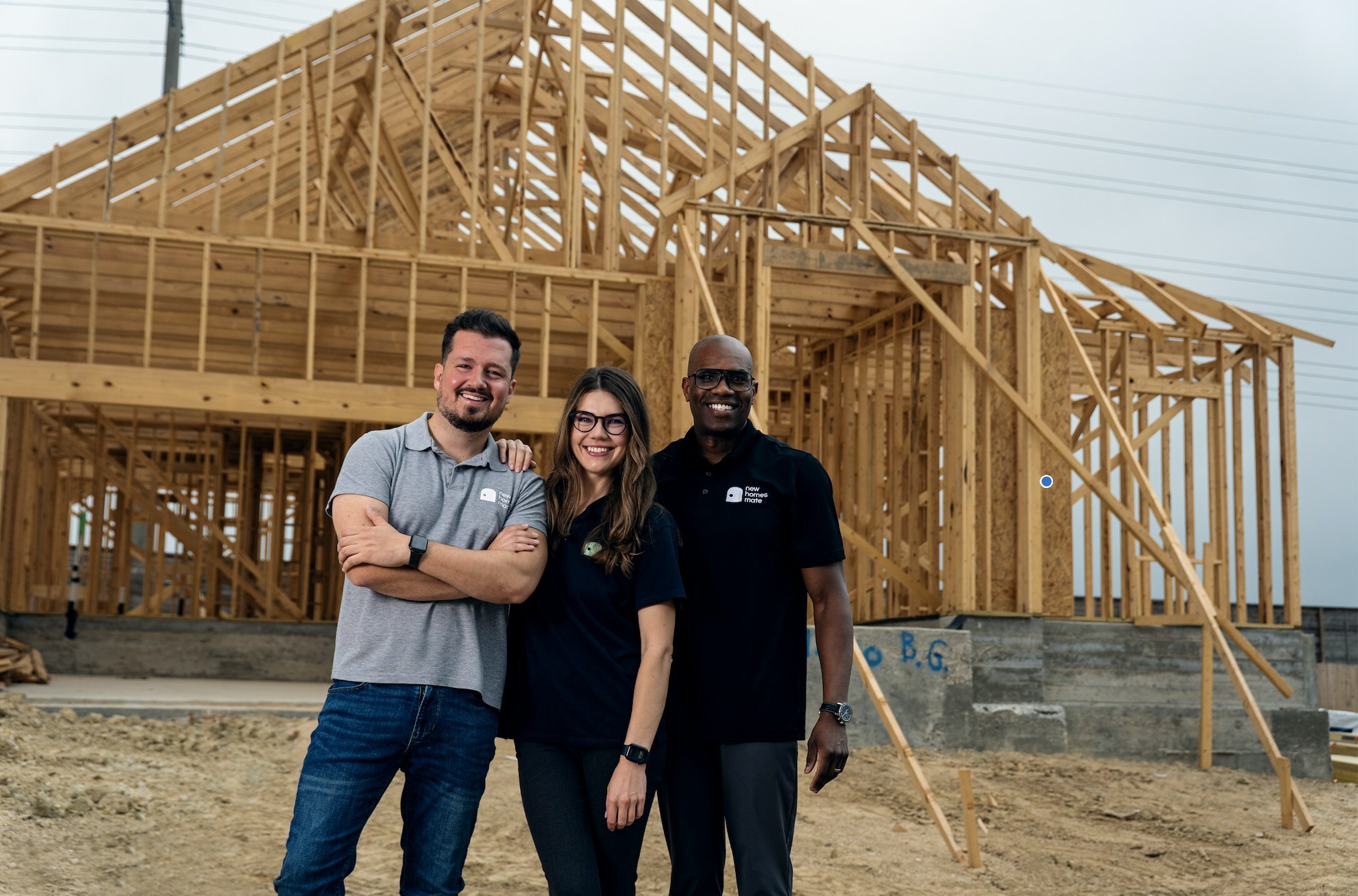 Members of the NewHomesMate executive team pose for a photo in front of an under-construction home.