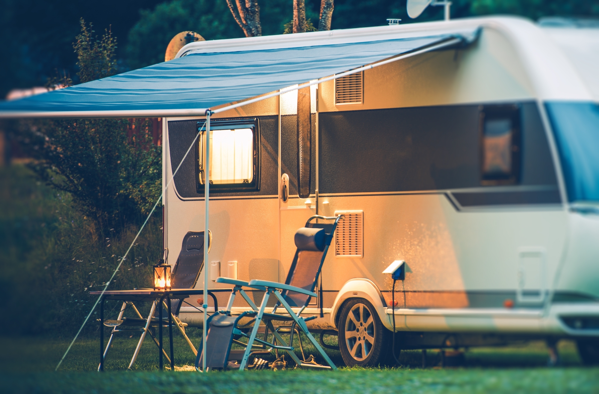 A camping trailer set up outside is pictured.