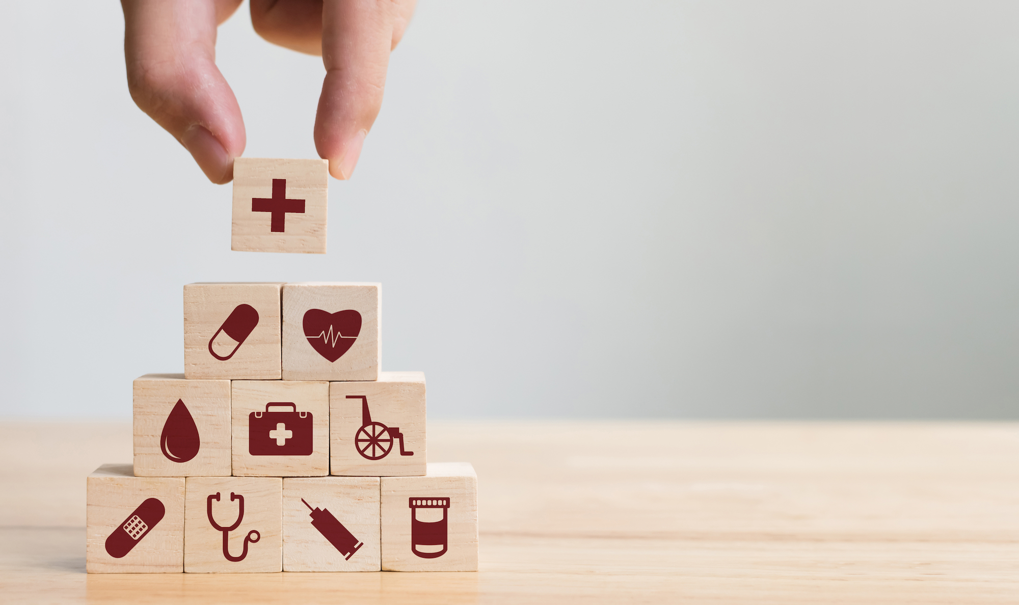 A stack of blocks with healthcare symbols on them is pictured.