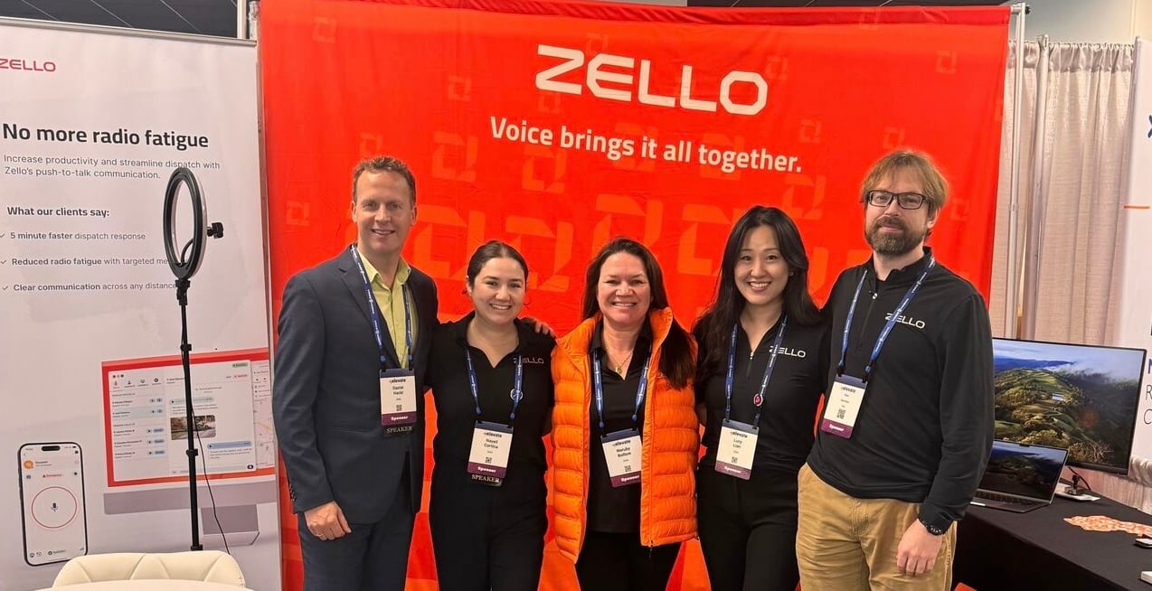 Zello team members pose at a conference booth.